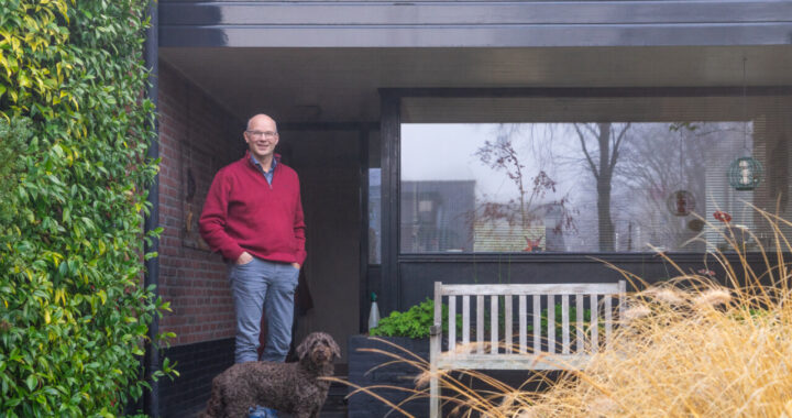 Barry Hoogendoorn staat samen met zijn hond voor zijn huis in Hilversum.